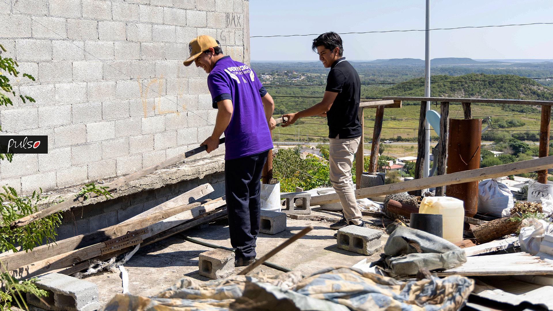 Alumnos ayudando a la Sra. Juana, a limpiar el techo de la casa. Fotografía por Universidad de Montemorelos / Lisandra Vicente.