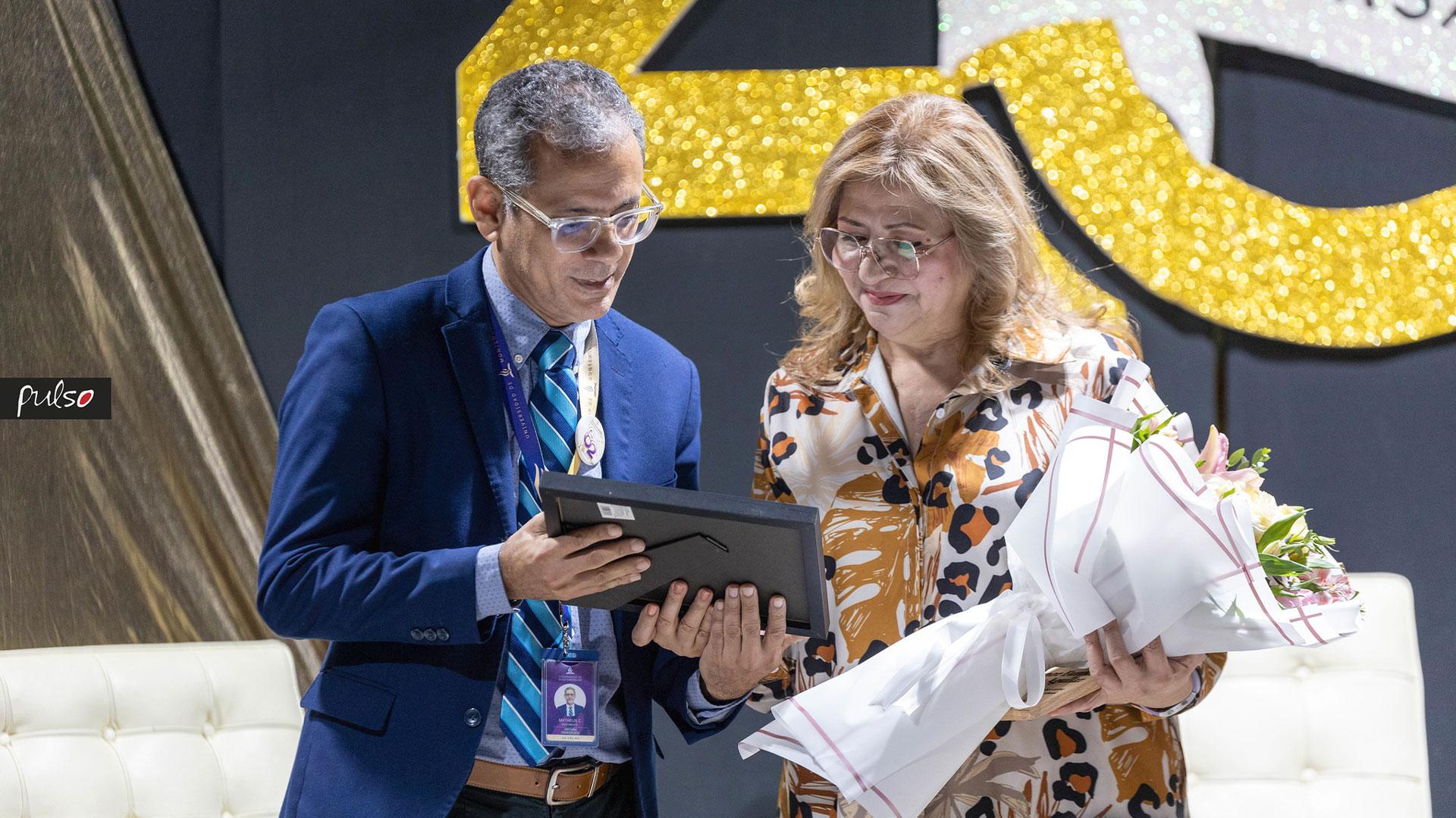 El Mtro.&nbsp; Matheus Nascimento, director de la ESART entregó el reconocimiento a la&nbsp;Mtra. Eunice Aguilar,&nbsp;quien fue alumna, docente, y directora de la Licenciatura en Artes Visuales. Fotografía por: Universidad de Montemorelos / Christopher Castellanos.
