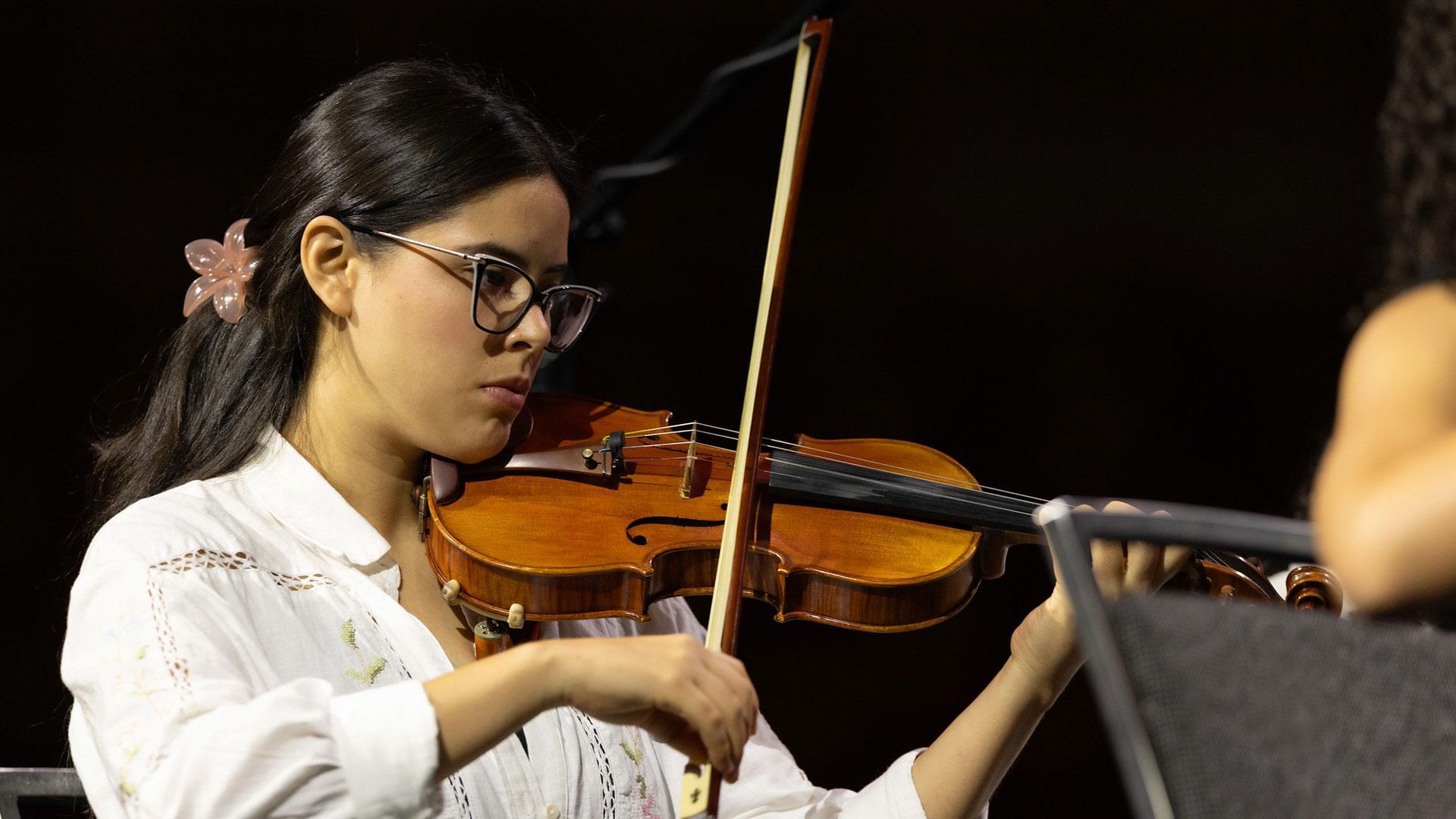 Paulette Pérez, estudiante de odontología en la UM, toca el violín durante una actuación musical el 5 de julio de 2025, durante el Congreso de la Asociación General. Fotografía por: DIA / Daniel Gallardo.