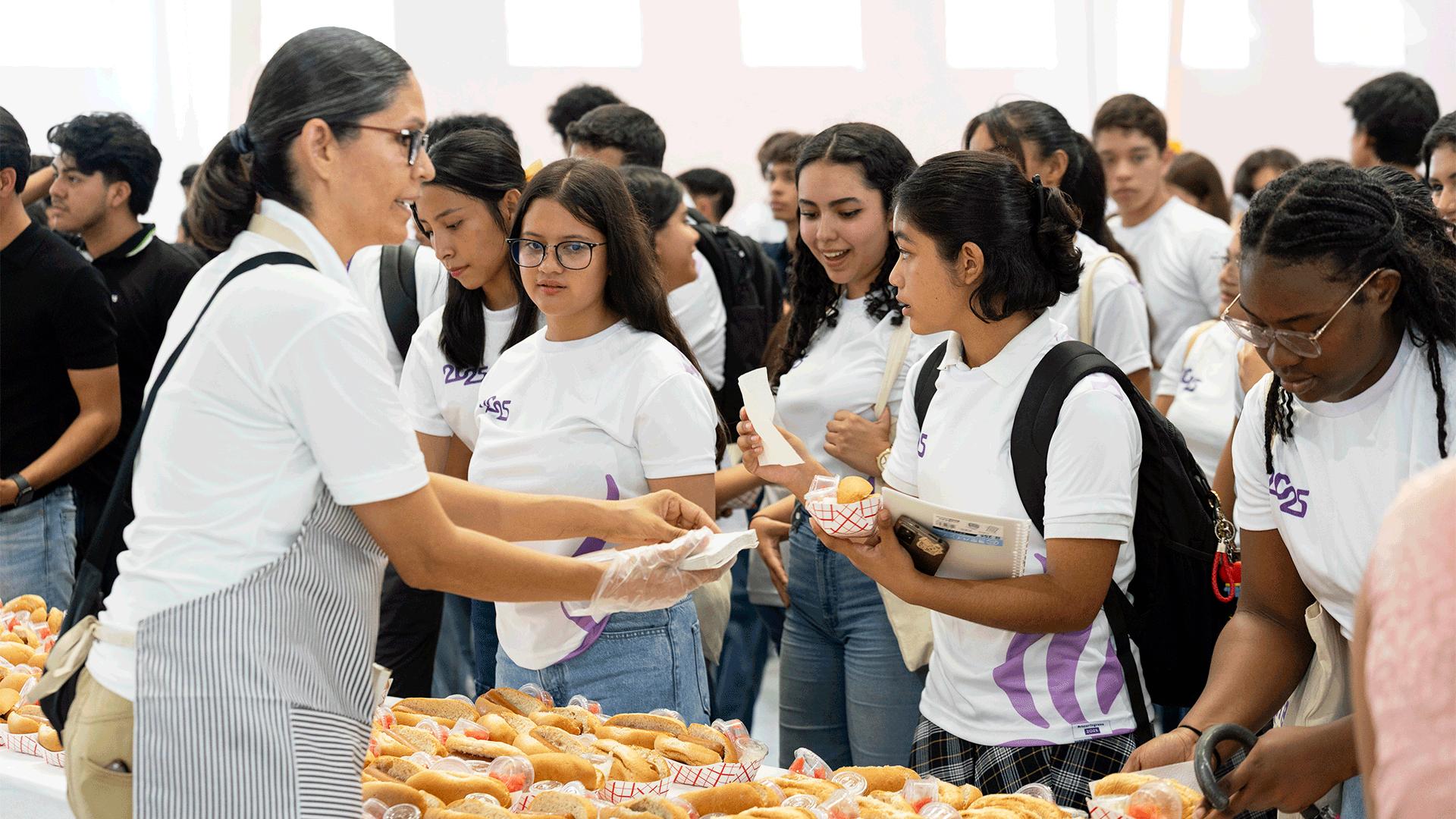 Alumnos de nuevo ingreso participando en el tradicional hot dog gigante.&nbsp; Fotografía por: Universidad de Montemorelos / Abnel Vázquez.