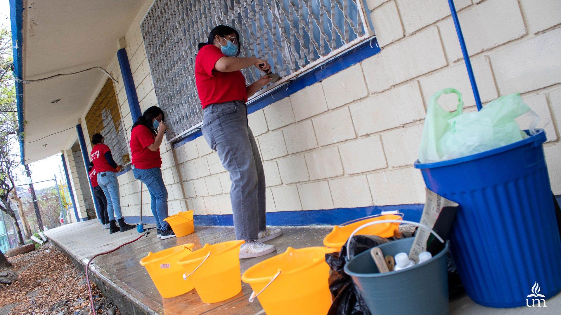 Alumnas limpiando las aulas que serán pintadas próximamente. Fotografía por: Comunicación Institucional / Lisandra Vicente.
