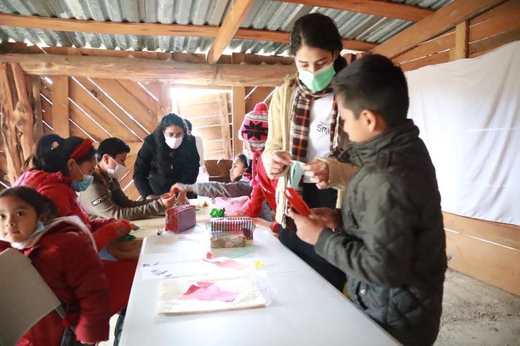 Los niños aprendiendo hacer figuras de papiroflexia con los voluntarios. Fotografía por: Esli Tello.