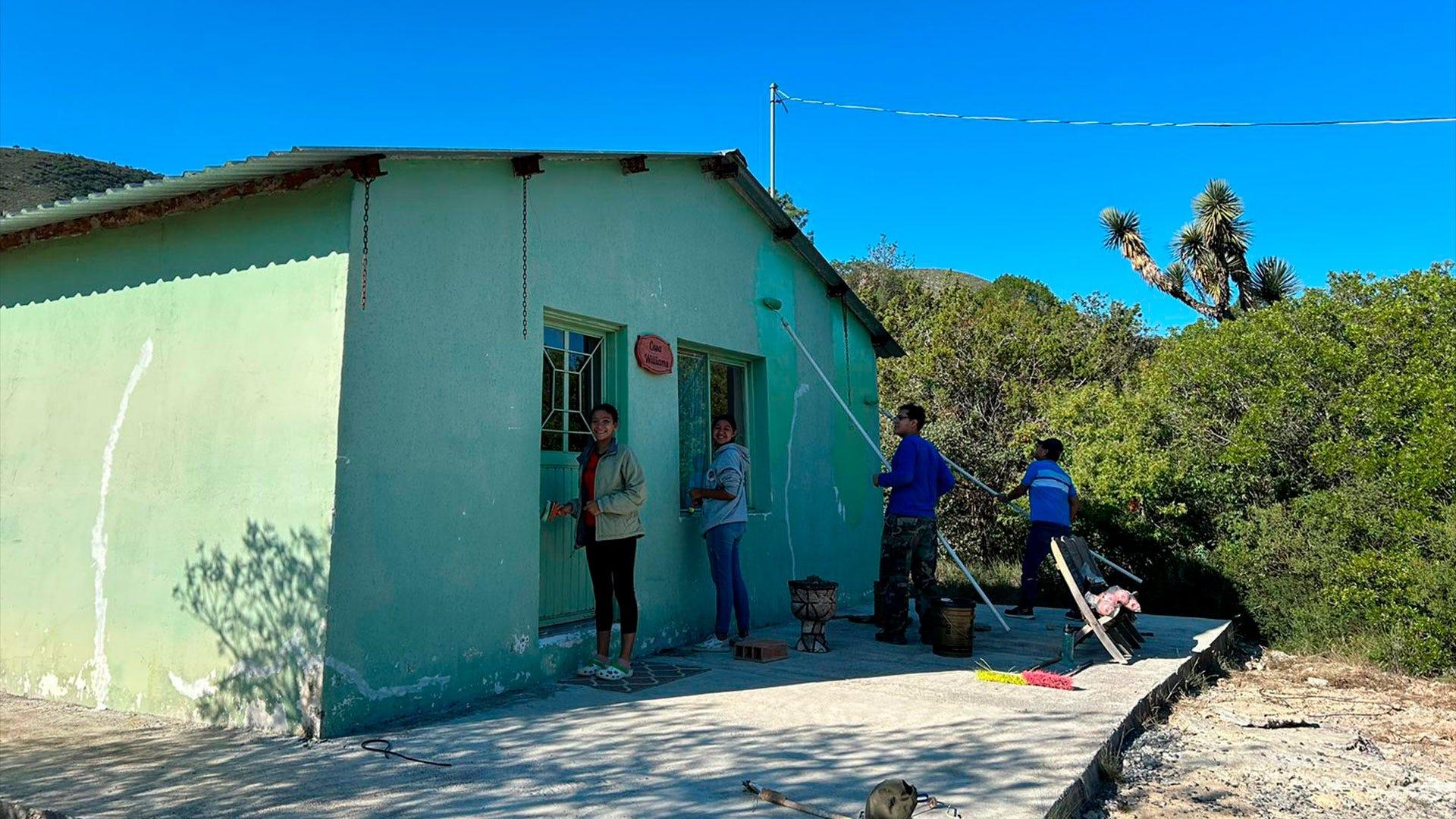Alumnos y docentes pintando una de las casas del Centro. Fotografías por: Escuela Preparatoria ICF.