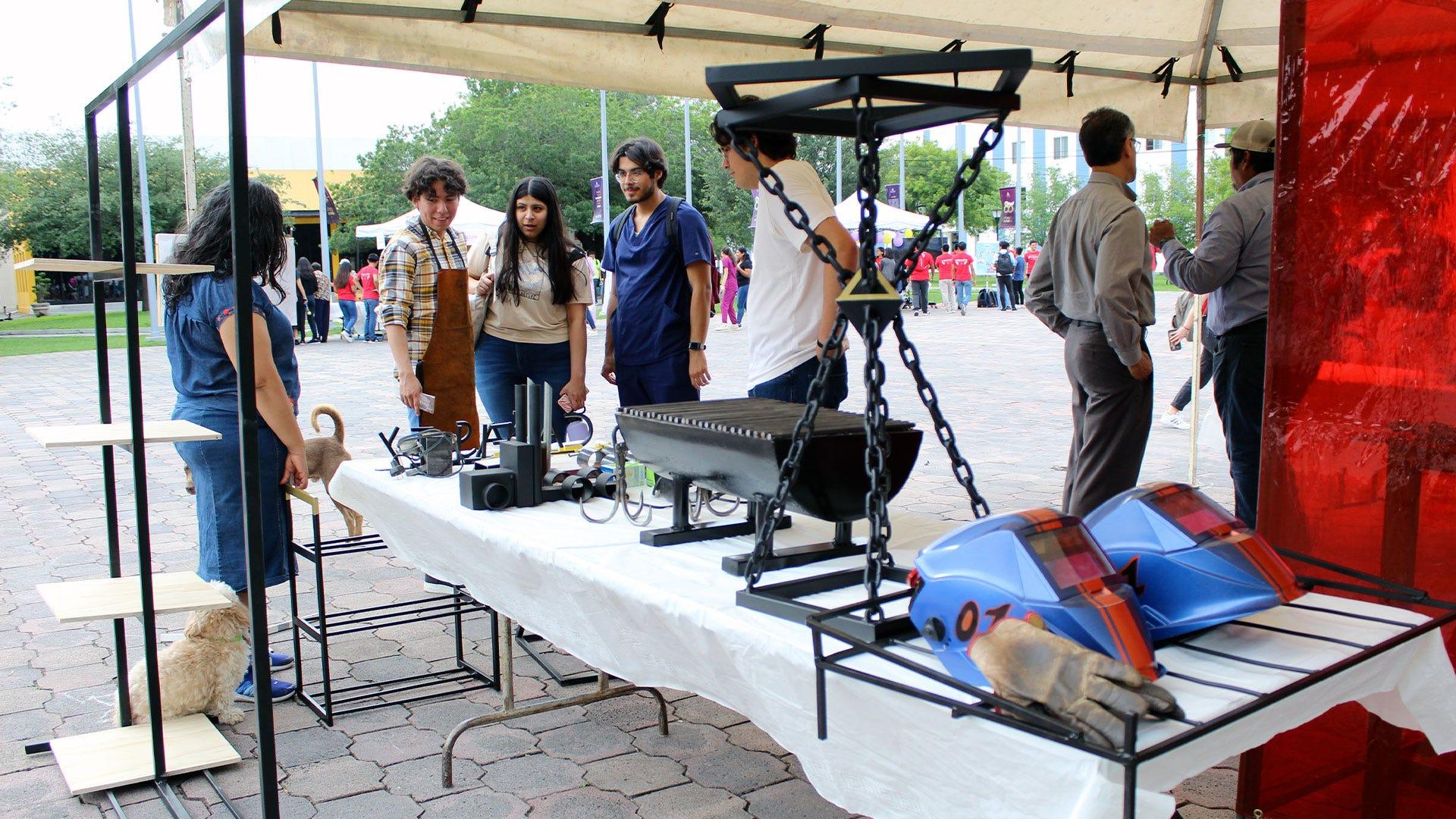 Alumnos presentando sus proyectos realizado en los talleres manueales de herrería. Fotografía por: Comunicación Institucional.