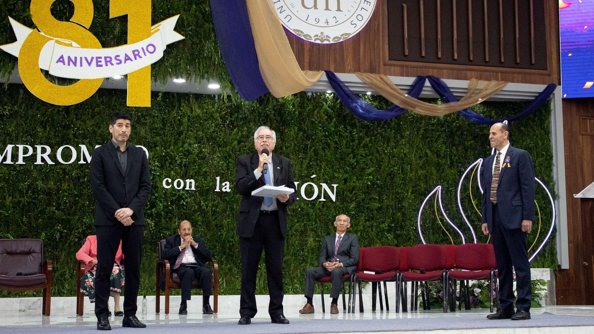 De izquierda a derecha, el Mtro. Walter Melo, director de la carrera de Comunicación y director de Comunicación Institucional de la Universdad Adventista del Plata; el Dr. Daniel Gutiérrez, actualmente es asesor del Rector de la Universidad Adventista del Plata; entregando el reconocimiento especial a la administración de la UM por sus 81 años y su compromiso con la educación cristiana al Dr. Ismael Castillo, rector de la Institución. Fotografía por: Comunicación Institucional / Lisandra Vicente.