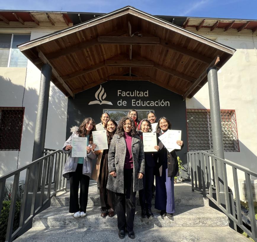 La maestra Blanco, quien preparó a este grupo de alumnas para el examen, junto a las alumnas frente al edificio de la Facultad de Educación, portando el certificado. Fotografía cortesía de la doctora Rosalba Ortiz.