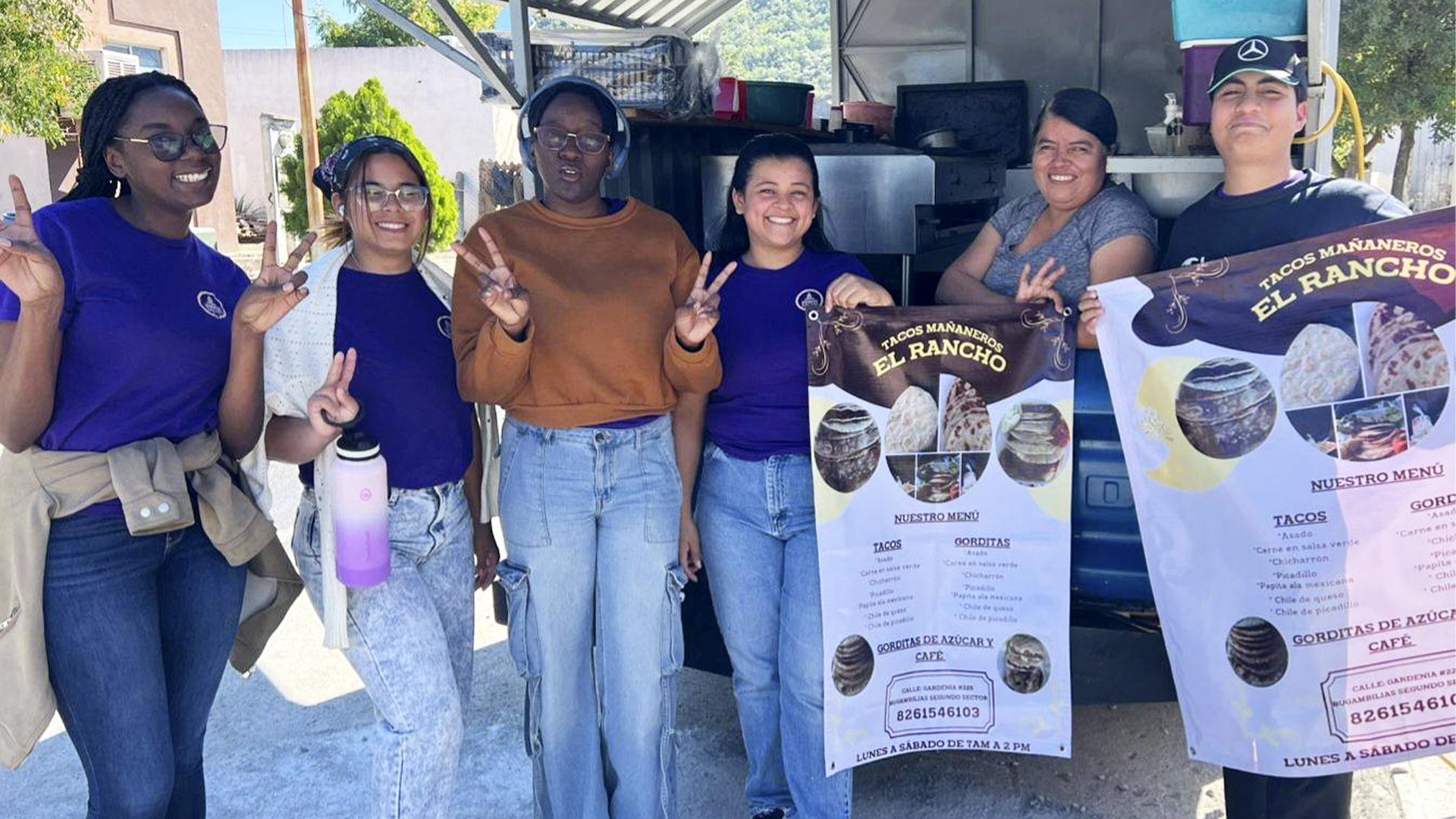 Estudiantes de la FACEJ colaboran con un pequeño negocio local mediante la entrega de un banner publicitario. Fotografía cortesía de UPS.