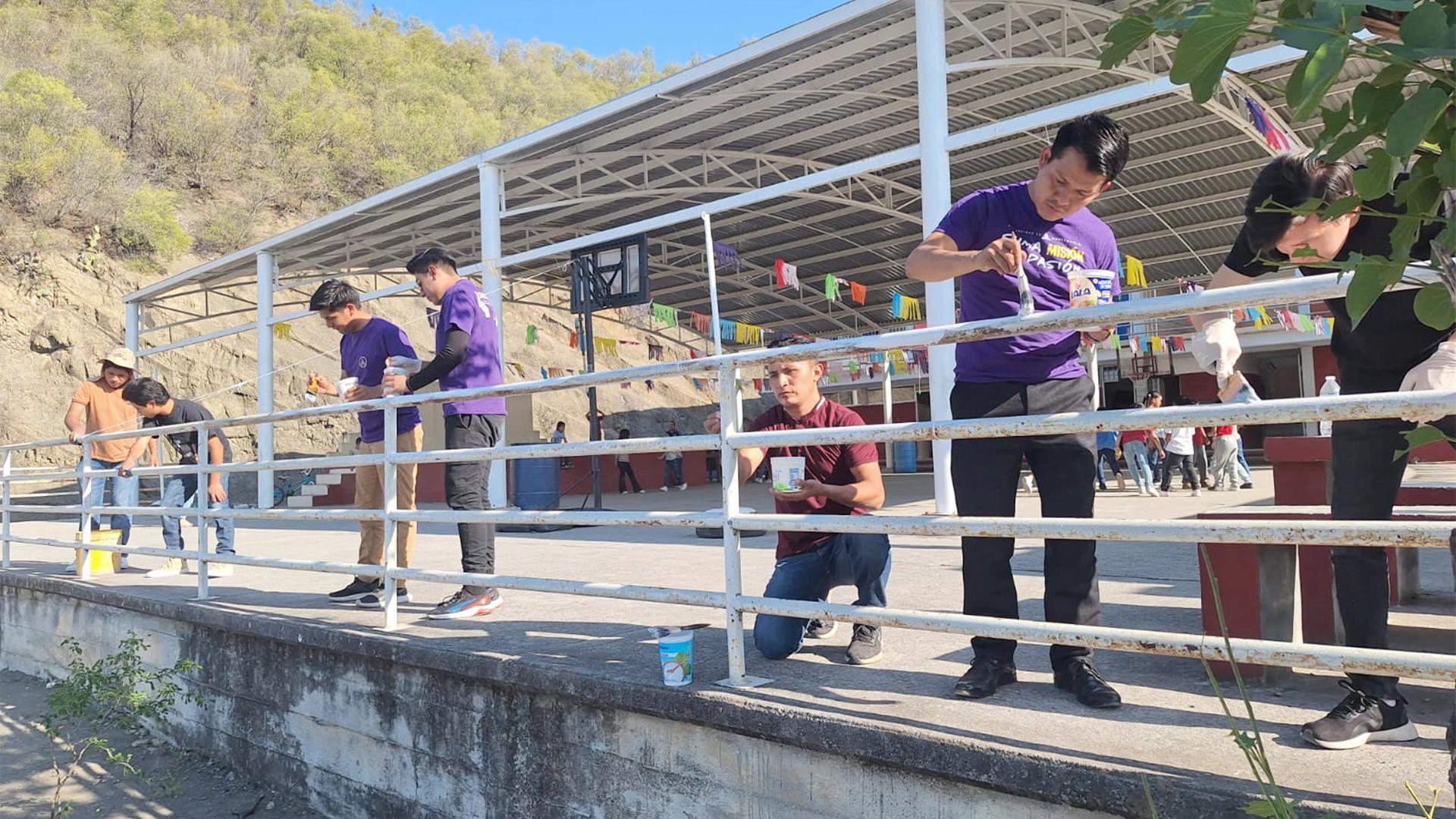 Estudiantes pintando los barandales de la escuela. Fotografía cortesía de Héctor Armenta.