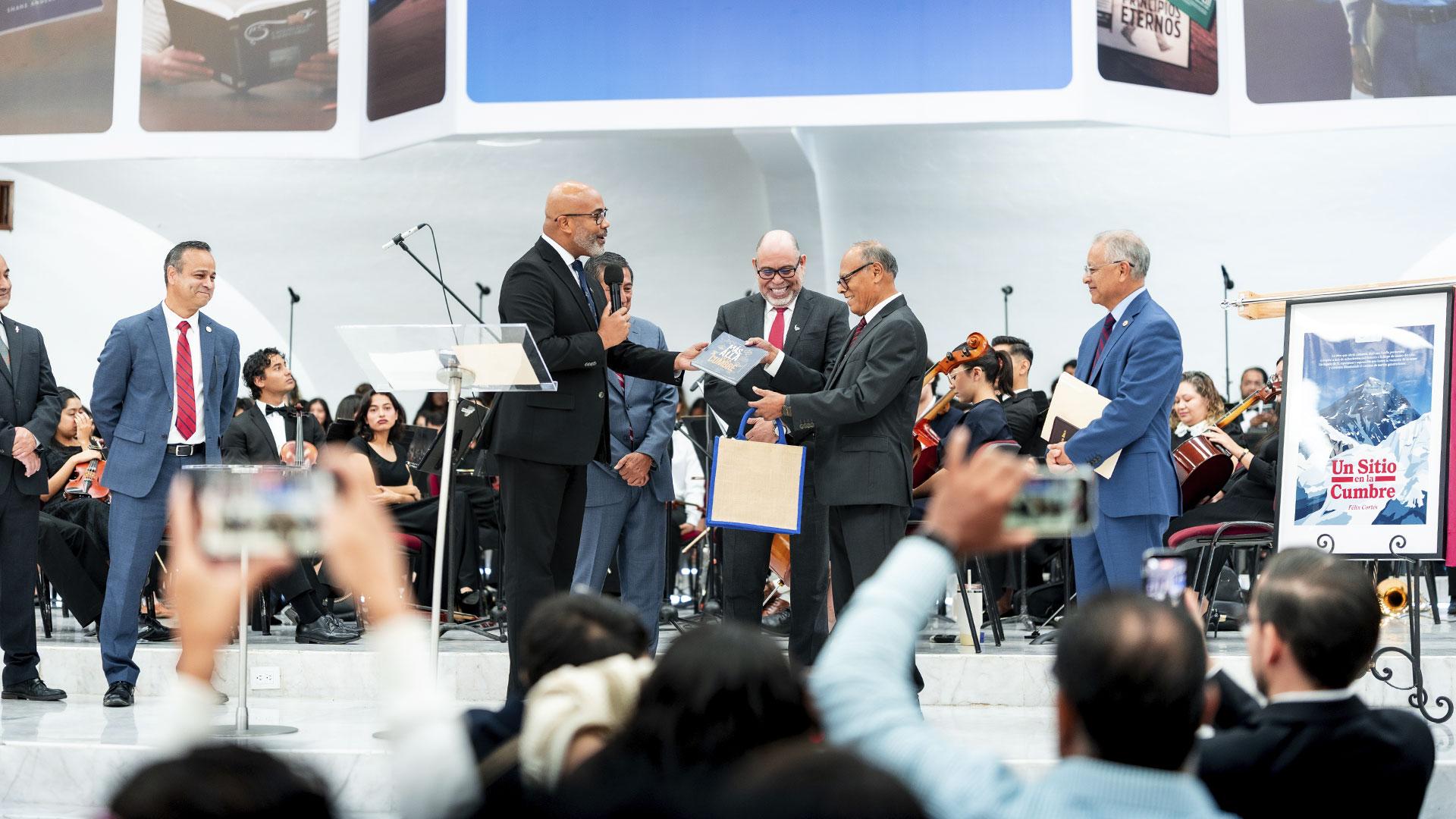 El Ptr. Vladimir Polanco, director de IADPA, entregando un reconocimiento al Ptr. Félix Cortés, por sus reimpresiones y traducciones de la obra "Un sitio en la cumbre". Fotografía por: Universidad de Montemorelos / Eliseo Naranjo.
